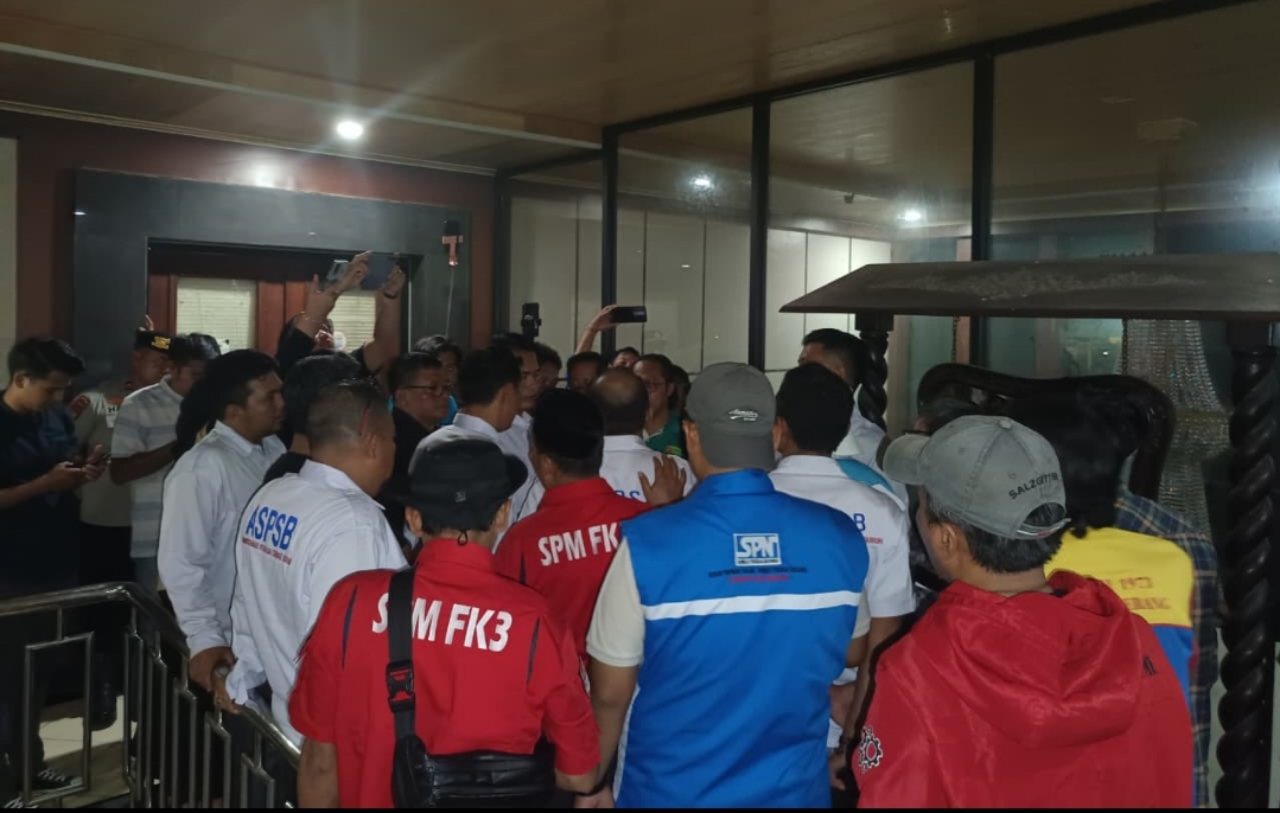 Buruh melakukan orasi di depan Gedung Setda Kabupaten Serang saat rapat Dewan Pengupahan berlangsung hingga malam hari, Jumat, 19 Desember 2025.
