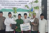 Penyerahan simbolis kepesertaan BPJS Ketenagakerjaan kepada marbot dan imam masjid dalam acara Halalbihalal PCNU Kabupaten Serang di Ponpes Nurul Abror.