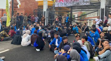 Puluhan mahasiswa PMII Kota Serang menggelar aksi demonstrasi di depan Gedung DPRD Banten sambil membawa spanduk tuntutan terkait pendidikan dan ketenagakerjaan.