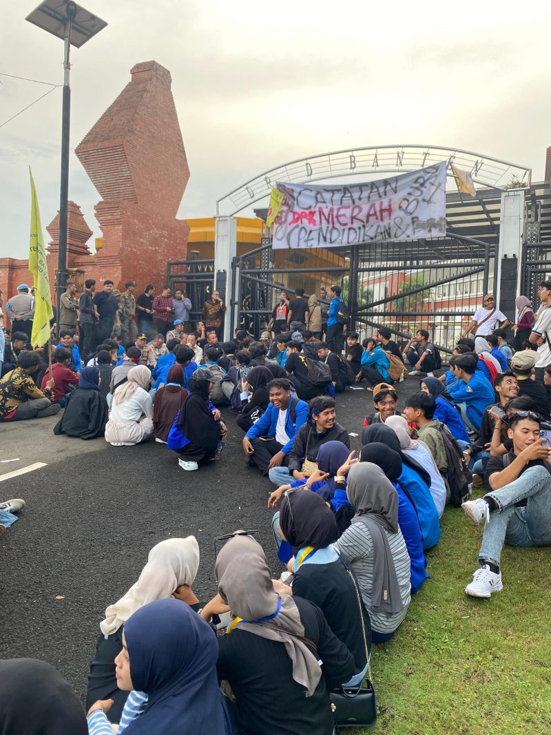 Puluhan mahasiswa PMII Kota Serang menggelar aksi demonstrasi di depan Gedung DPRD Banten sambil membawa spanduk tuntutan terkait pendidikan dan ketenagakerjaan.