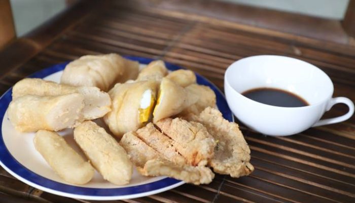 Pengunjung menikmati sajian pempek khas Palembang dengan kuah cuko hitam di Warkop AA Hendy X Pempek 88, Kota Tangerang