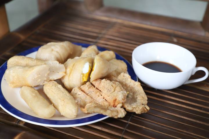 Pengunjung menikmati sajian pempek khas Palembang dengan kuah cuko hitam di Warkop AA Hendy X Pempek 88, Kota Tangerang