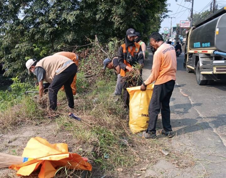 Petugas DLH Kota Tangerang membersihkan tumpukan sampah dan ranting pohon di trotoar Jalan Marsekal Surya Darma demi menjaga kenyamanan pengguna jalan