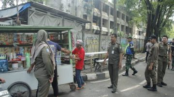 Petugas Satpol PP Kota Tangerang menertibkan pedagang kaki lima yang berjualan di trotoar kawasan Alun-Alun Ahmad Yani.