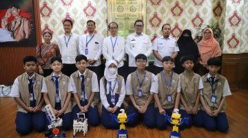 Tim robotik SMP PGRI 2 Ciledug menunjukkan piala dan penghargaan usai meraih juara nasional dalam kompetisi Robot for Mission 2026 di Bandung.