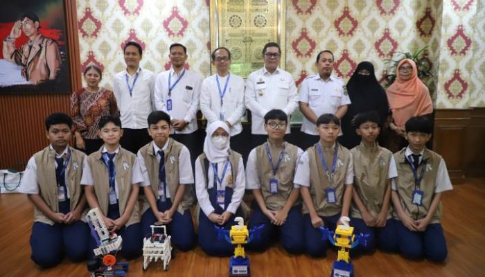 Tim robotik SMP PGRI 2 Ciledug menunjukkan piala dan penghargaan usai meraih juara nasional dalam kompetisi Robot for Mission 2026 di Bandung.