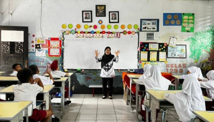 Seorang ayah mendampingi anaknya saat menerima rapor di sekolah. Pemkot Tangerang mendorong keterlibatan aktif ayah dalam pendidikan melalui Gerakan Ayah Mengambil Rapor ke Sekolah.