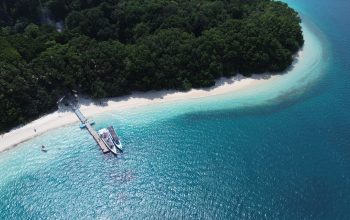 Wisatawan menikmati panorama pantai berpasir putih dan air laut jernih di Pulau Peucang, kawasan Taman Nasional Ujung Kulon, Kabupaten Pandeglang, Banten.