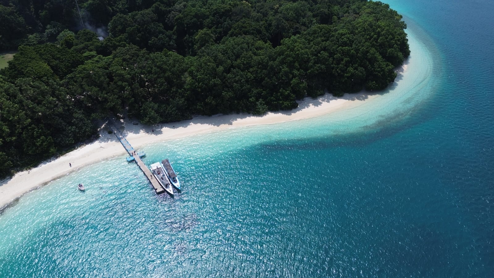 Wisatawan menikmati panorama pantai berpasir putih dan air laut jernih di Pulau Peucang, kawasan Taman Nasional Ujung Kulon, Kabupaten Pandeglang, Banten.