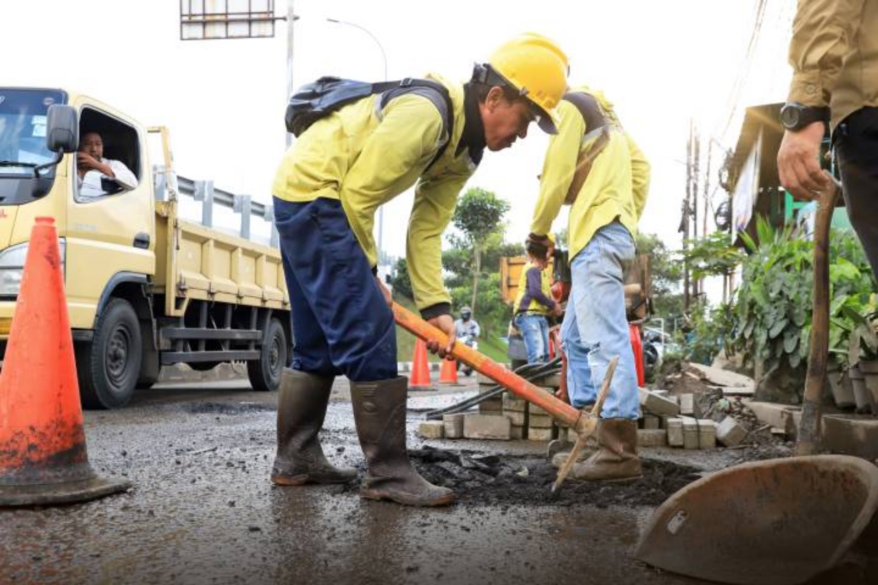 Petugas Dinas PUPR Kota Tangerang melakukan perbaikan jalan menggunakan material hotmix di salah satu ruas jalan prioritas untuk meningkatkan kenyamanan dan keselamatan pengguna jalan.