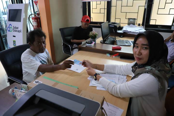 Petugas Disdukcapil Kota Tangerang melayani masyarakat yang mengajukan penggantian foto KTP-el dengan prosedur baru yang lebih sederhana tanpa surat pengantar RT/RW.