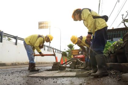 Petugas memperbaiki jalan rusak dalam program Pemkot Tangerang Ajak Masyarakat Laporkan Jalan Rusak melalui kanal pengaduan resmi.
