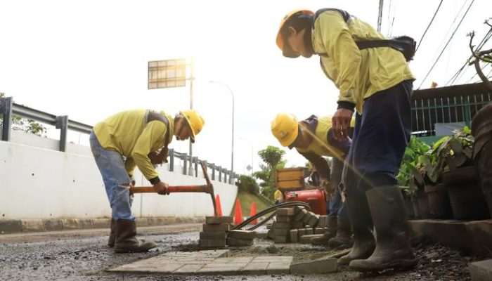 Petugas memperbaiki jalan rusak dalam program Pemkot Tangerang Ajak Masyarakat Laporkan Jalan Rusak melalui kanal pengaduan resmi.
