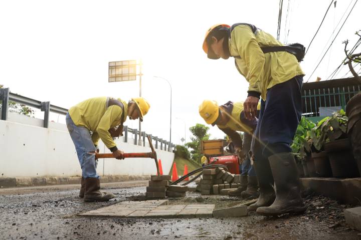 Petugas memperbaiki jalan rusak dalam program Pemkot Tangerang Ajak Masyarakat Laporkan Jalan Rusak melalui kanal pengaduan resmi.