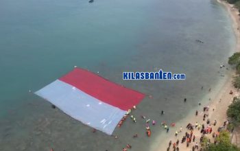 Peserta membentangkan Bendera Merah Putih di perairan Pulau Merak Besar, Kota Cilegon, usai mengikuti aksi transplantasi terumbu karang dan pelepasan tukik dalam rangka peringatan HUT RI ke-81.