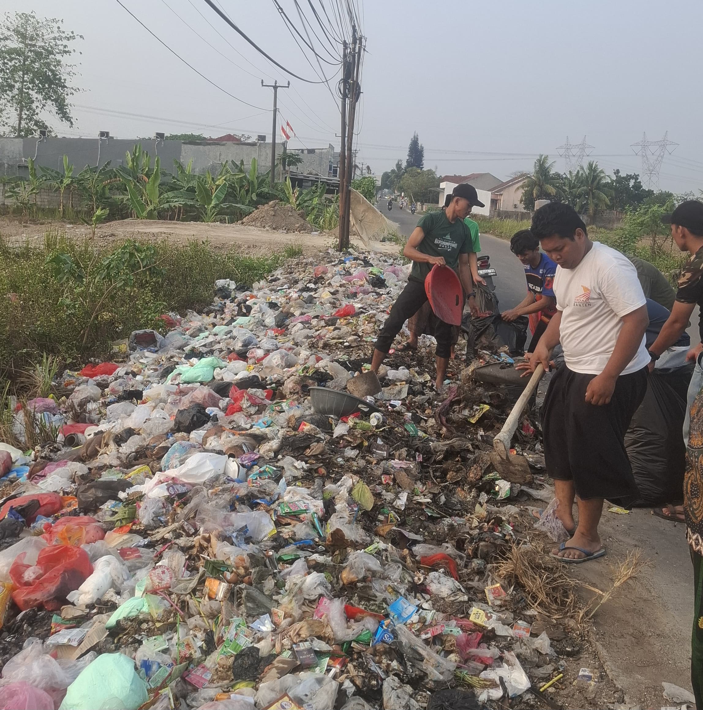 Pengurus MWCNU Kragilan bersama Banser, Ansor, dan warga bergotong royong membersihkan tumpukan sampah di salah satu ruas jalan di Kecamatan Kragilan, Kabupaten Serang, Selasa (11/8/2026).